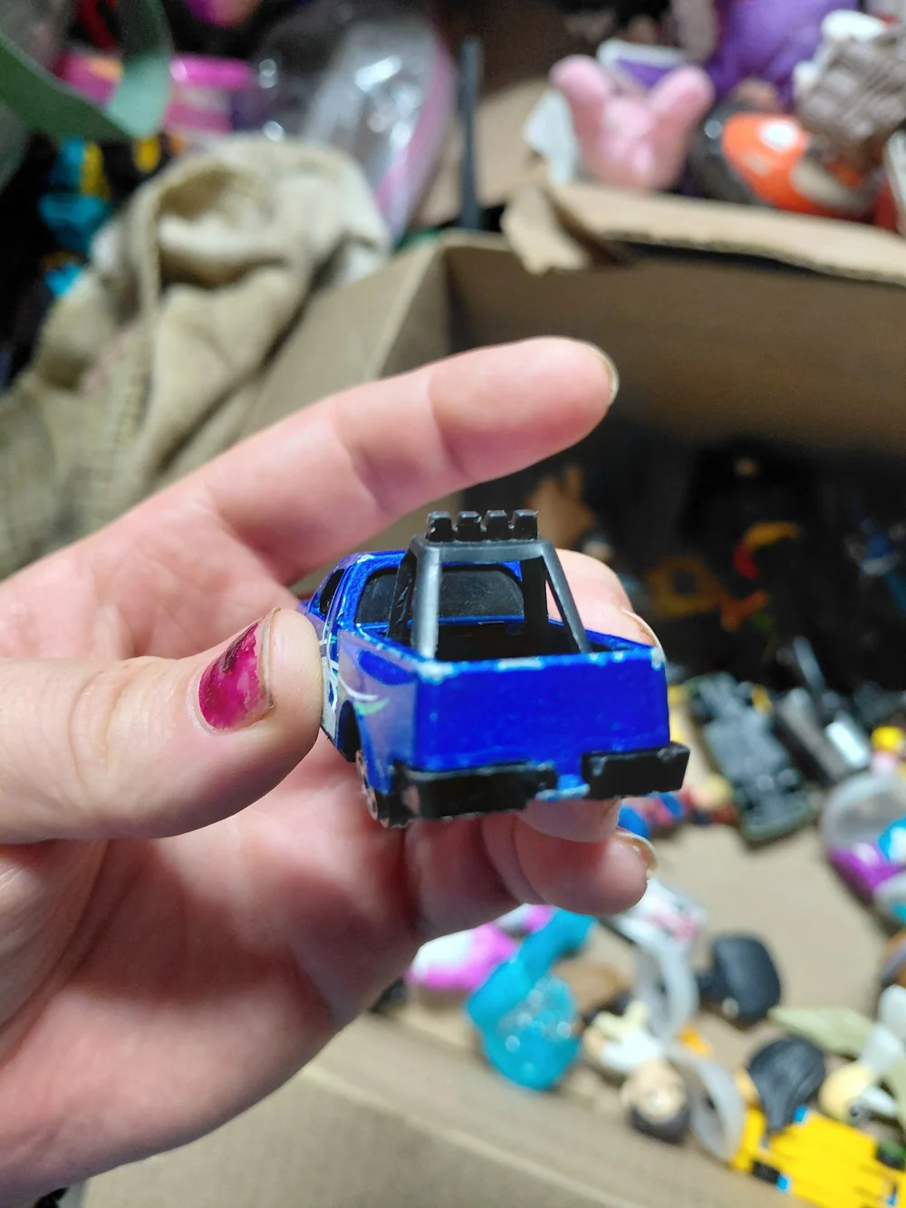blue diecast pickup truck is a 1:64 scale model, possibly from a 